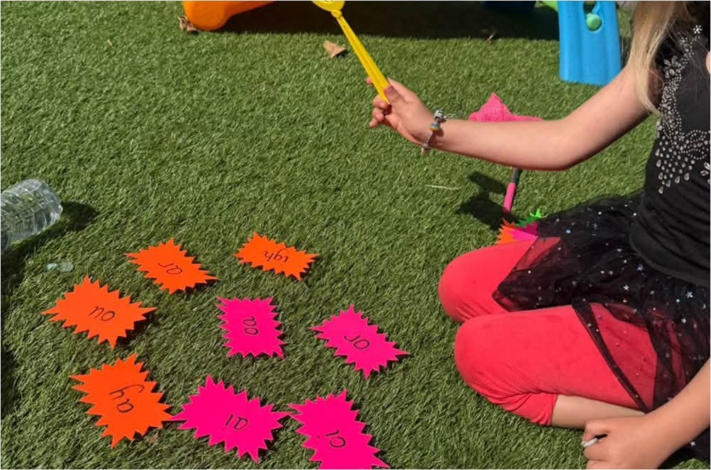 A phonics sounds game out on the grass