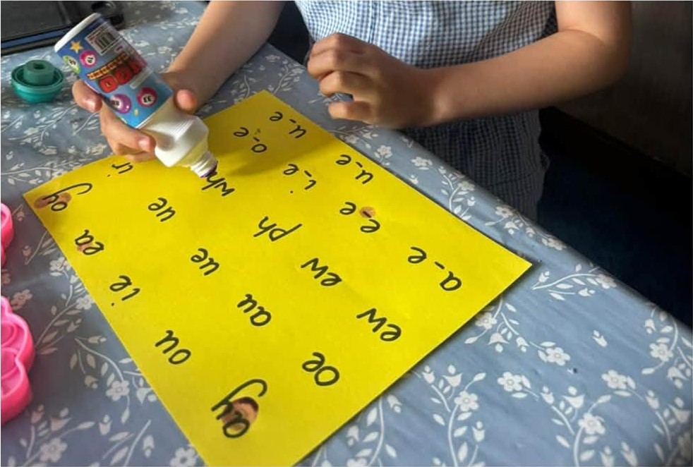 Dotting phonics sounds on a bright chart